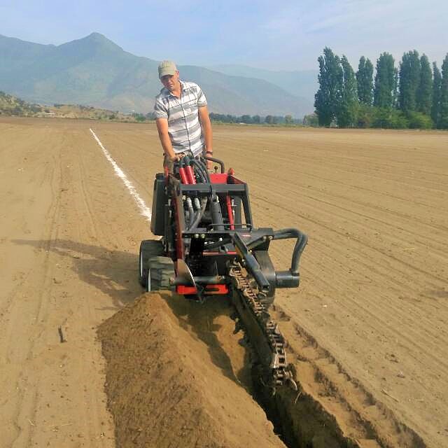 Operario de Mi Riego instalando riego con máquina zanjadora